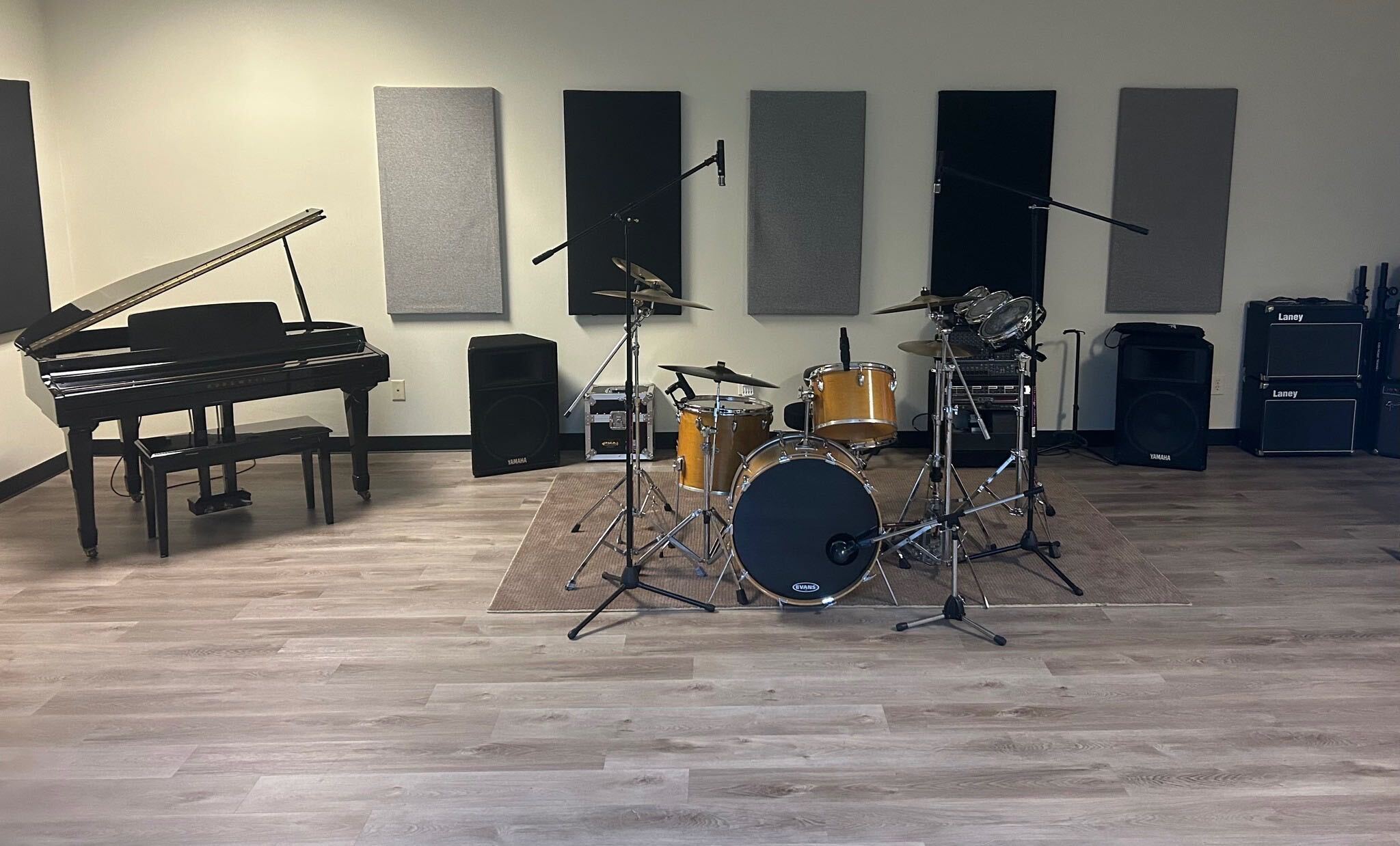 Live room with piano, drums, and guitar amps